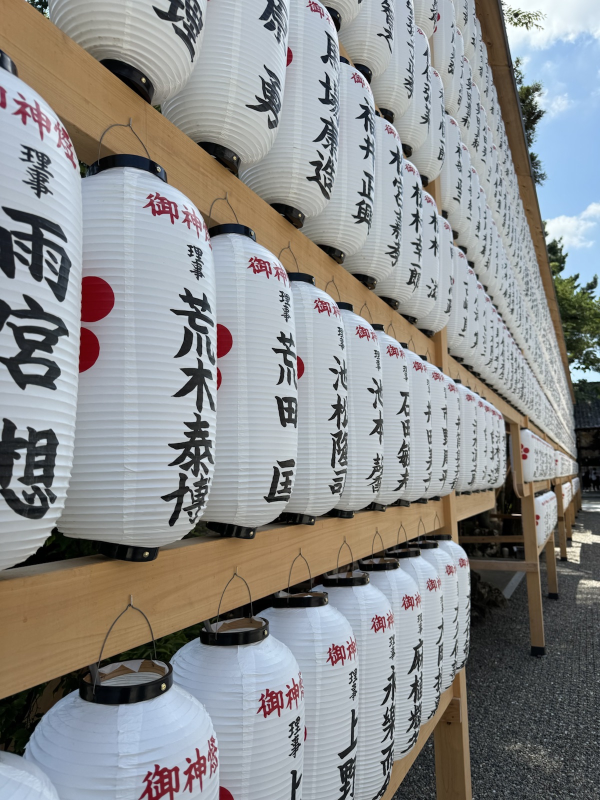 Rows of white paper votive lanterns at a Kyoto shrine, each hand-lettered with a patron's name
